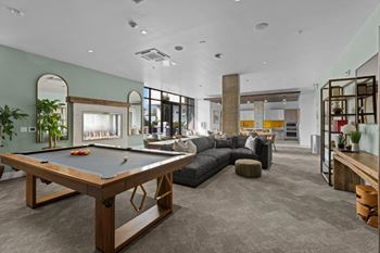 A room with a pool table and a couch.